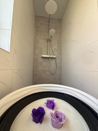 a bath tub with purple towels in a bathroom at Pure Wellness Bungalows 121 Sauna&Massage&Hottub in Ewijk