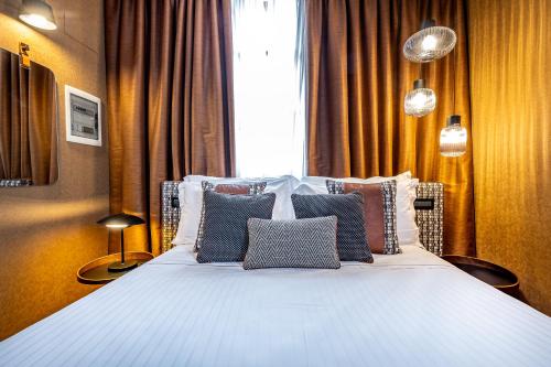 a bedroom with a large bed with many pillows at Hotel Duomo Firenze in Florence
