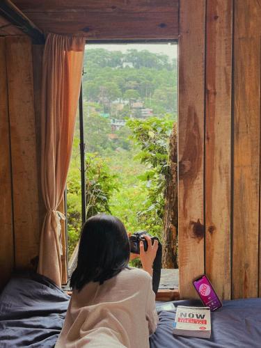 a woman taking a picture of a window at Cú Trên Cây Homestay in Xuan An