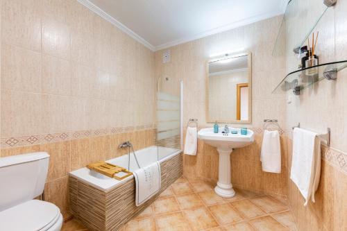 a bathroom with a toilet and a sink and a tub at Apartamento Loli in Aguadulce
