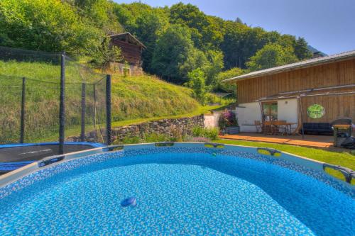 - une piscine dans une cour à côté d'un bâtiment dans l'établissement Chalet la Ficle, à Saint-Jean-dʼAulps