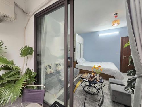 a small room with a bed and a glass door at The Chilling'N Homestay Ha Noi 89 in Hanoi