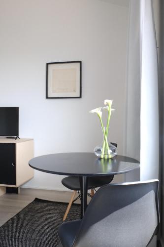 a black table with a vase of flowers on it at The Black Sheep BnB in Arbus