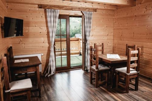 a dining room with a table and chairs and a window at Rekreačný dom - Chata pod Lampášom in Terchová