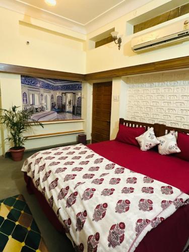 a bedroom with a large bed with a red blanket at Travellers Village-City Center Hertige Home in Jaipur