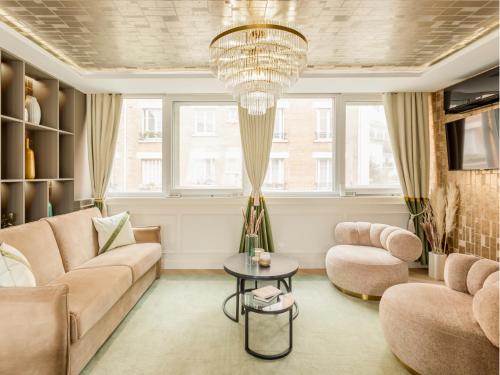 - un salon avec un canapé et un lustre dans l'établissement Merveil - Luxury Suite - Tour Eiffel - Fremicourt, à Paris