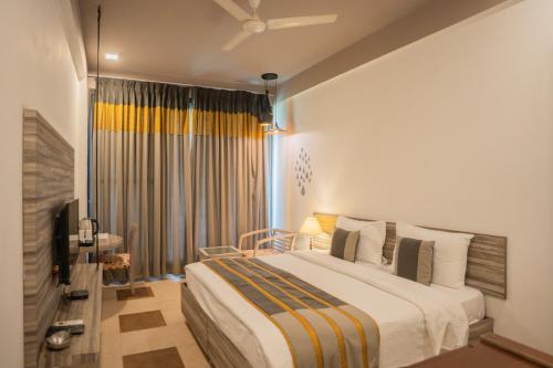 a bedroom with a large bed and a television at Ahuja Residency Parklane in Gurgaon
