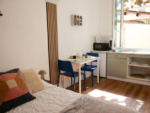 une chambre avec un lit et une table et une cuisine dans l'établissement La Petite Adresse Studio-Grange Blanche-Lyon 3, à La Celle-sous-Gouzon