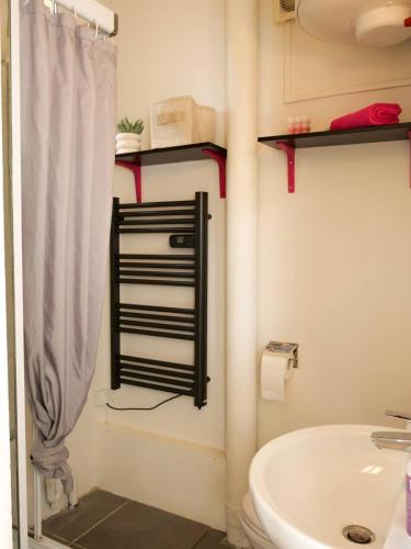 une salle de bain avec une baignoire blanche et un lavabo dans l'établissement La Petite Adresse Studio-Grange Blanche-Lyon 3, à La Celle-sous-Gouzon