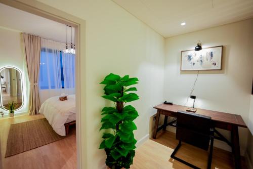 a room with a bedroom with a desk and a plant at Noya Yas Island Luxury Retreat 5 Star Stay in Abu Dhabi