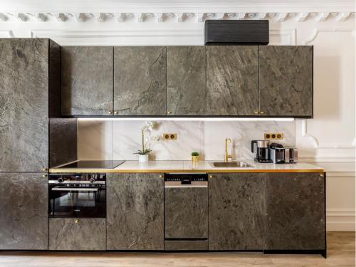 une cuisine avec des armoires en acier inoxydable et un évier dans l'établissement Merveil - Luxury Suite - Champs Elysees - Boissy, à Paris