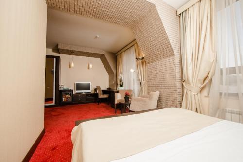 バクーにあるPassage Luxury Rooms Hotelのベッドとリビングルームがあるホテルの部屋