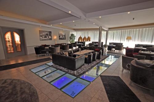 a lobby with couches and a tables and chairs at Hotel Alpen Residence in Ehrwald