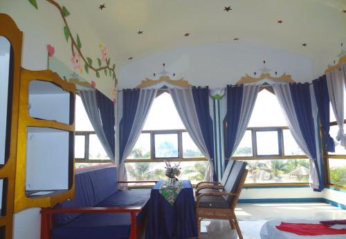 a room with windows and a table and chairs at MG Chateau Resort in El Nido