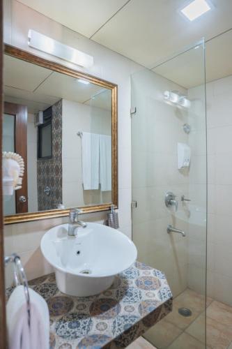 a bathroom with a sink and a shower at Ahuja Residency Parklane in Gurgaon