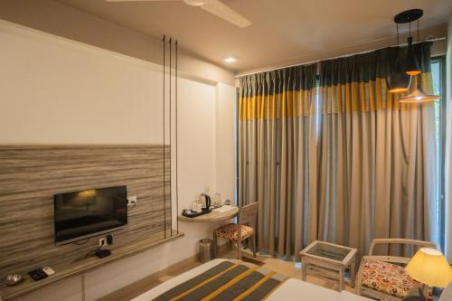 a hotel room with a bed and a large window at Ahuja Residency Parklane in Gurgaon