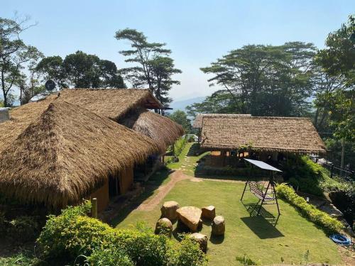 two thatched huts with a garden in front at Hanthana Eco Lodge in Kandy