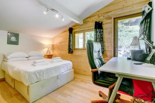 une chambre avec un lit et un bureau dans l'établissement Chalet la Ficle, à Saint-Jean-dʼAulps