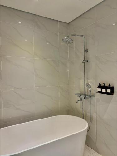 a bathroom with a white tub and a shower at D ELEGANCE GRAND BANDAR SERI ALAM in Masai
