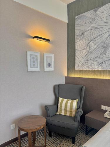 a hotel room with a chair and a table at D ELEGANCE GRAND BANDAR SERI ALAM in Masai