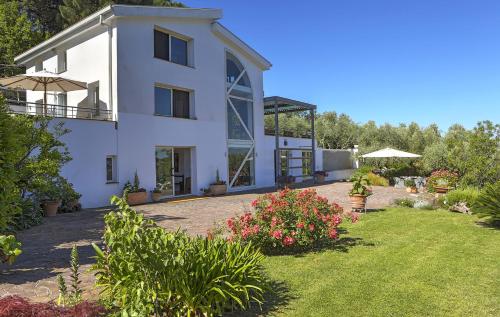 a large white house with a yard with flowers at Luxury Villa Lanuvio - Piscina e Hammam by Flatinrome in Lanuvio