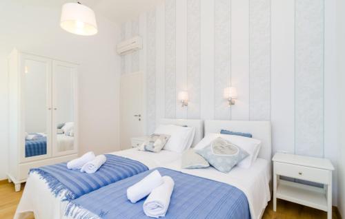 two beds in a bedroom with white and blue at Villa Blue by Villas Guide in Dubrovnik