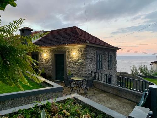 a small house with a table and chairs on a balcony at Amélia's House in Seixal