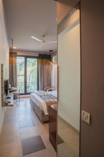 a bedroom with a bed and a large window at Ahuja Residency Parklane in Gurgaon