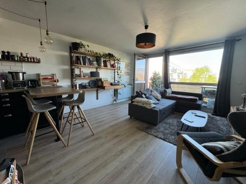 un salon avec un canapé et une table dans l'établissement Appartement Bordeaux avec parking privé, à Bordeaux