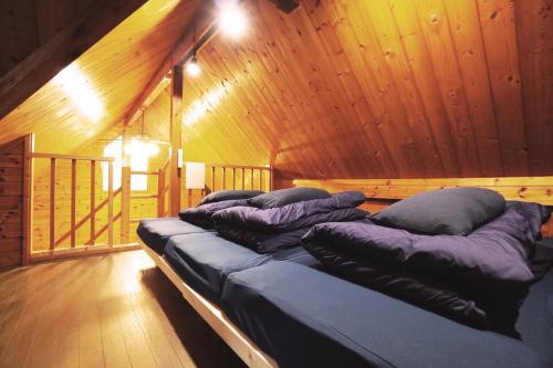 a row of pillows on a bed in a room at The Creek Cottage in Habu