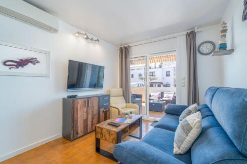 a living room with a blue couch and a tv at Basic Comfort Apartment Pattaya 0158 in Empuriabrava