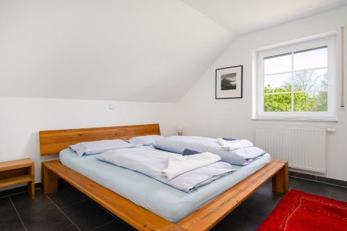 een bed met vier kussens in een kamer met een raam bij Ruhepol in Greetsiel