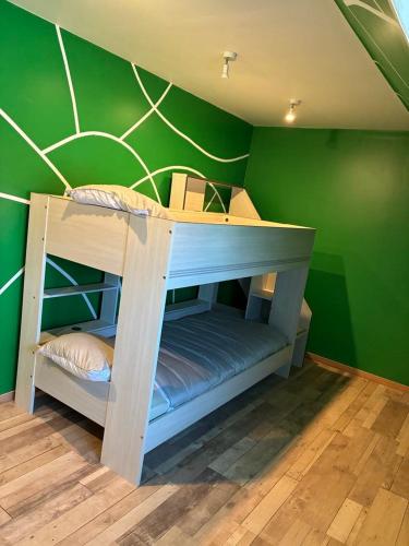 Ce lit superposé se trouve dans un dortoir doté d'un mur vert. dans l'établissement Gîte de L'océan, à Anguilcourt-le-Sart