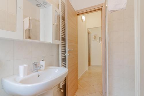 a white bathroom with a sink and a shower at Le Foyer du Bizet in Lierna