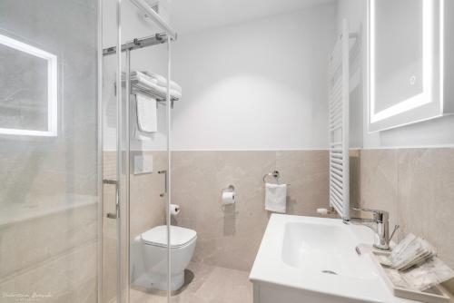a bathroom with a toilet and a sink and a shower at Hotel Adamas in Florence