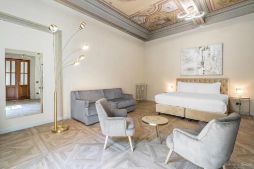 a hotel room with a bed and two chairs at Hotel Adamas in Florence