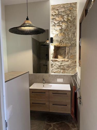 une salle de bain avec un lavabo et un mur en pierre dans l'établissement LA GRANGE - Maison de vacances - Entre lac et montagne, à Liausson