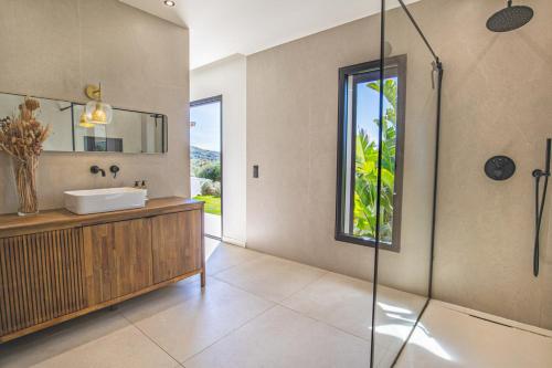une salle de bain avec un lavabo et une douche en verre dans l'établissement Villa MARE E MACCHIA, à Lecci