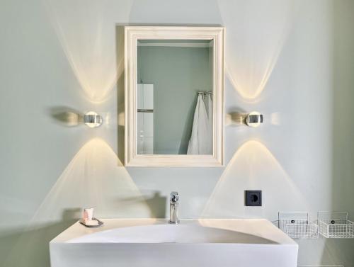 a bathroom with a white sink and a mirror at FEWO LÜNEBURG - Am Golfclub St Dionys in Sankt Dionys