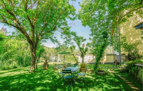 a yard with a table and chairs under a tree at Awesome Apartment In Il Ferrone in Mercatale Val Di Pesa
