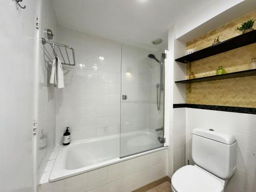 a bathroom with a shower and a toilet and a tub at Spacious Park Views with Spa, Pool, Gym, Netflix in Auckland