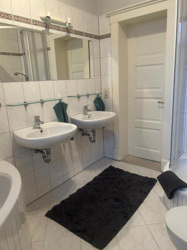 a bathroom with two sinks and a mirror at Landhausvilla Gut Vogelsang in Lalendorf
