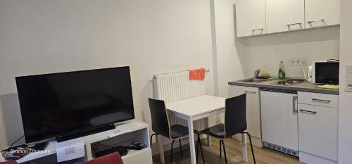 a small kitchen with a small table and a television at Zimmer in Würzburg Stadtmitte in Würzburg