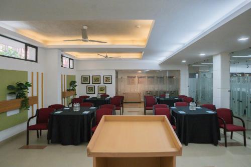 a conference room with tables and red chairs at Ahuja Residency Parklane in Gurgaon
