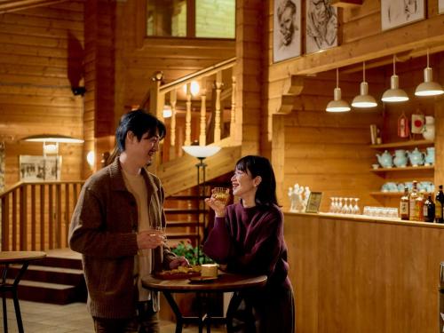 a man and woman standing at a table in a restaurant at Shizukuishi Prince Hotel in Shizukuishi