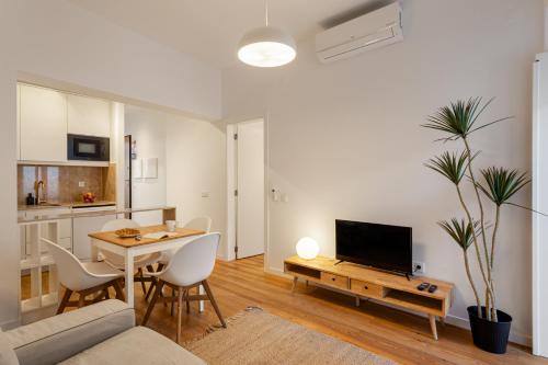 a living room with a table and a tv and a couch at Calçada de Santo Amaro Apartments in Lisbon