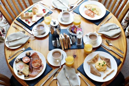 a wooden table with plates of breakfast food on it at Bronte Guest House in York