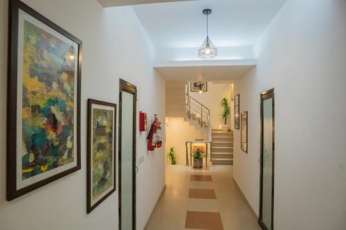 a hallway with paintings on the walls and stairs at Ahuja Residency Parklane in Gurgaon