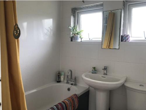 a bathroom with a sink and a tub and a toilet at Stylish Room Close to Beaches in Falmouth