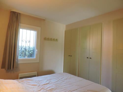 une chambre avec un lit et une fenêtre dans l'établissement Escapade ensoleillée aux Parcs de Grimaud, à Grimaud